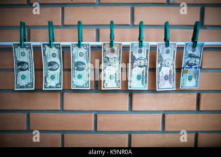 set of bills 1,2,5,10,20,50,100 dollars usa are drying on a white lath with Stock Photo