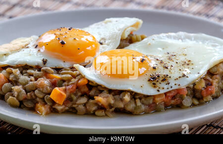 Delicious lentils with vegetable and fried egg close up Stock Photo