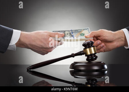 Close-up Of A Businessman Taking Bribe In Front Of Mallet Stock Photo