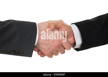 Close-up Of Two Businessman Shaking Hands Over White Background Stock Photo