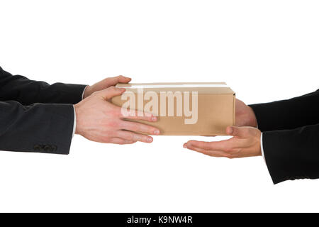 Close-up Of A Businessman Giving Box To His Colleague Over White Background Stock Photo