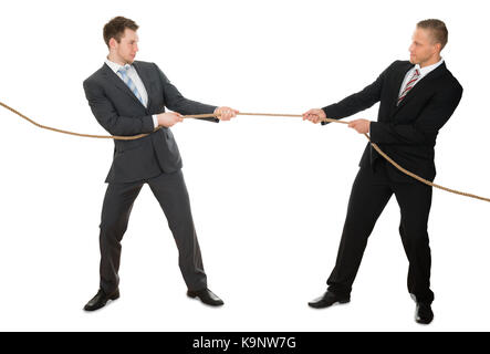 Portrait Of Two Businessman Pulling Rope Over White Background Stock Photo