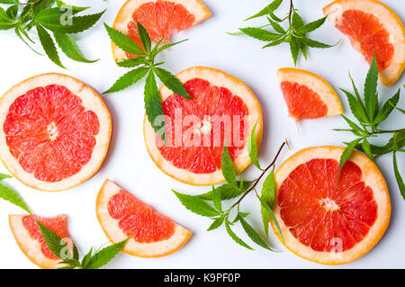 Grapefruit slices and marijuana leaves on white Stock Photo