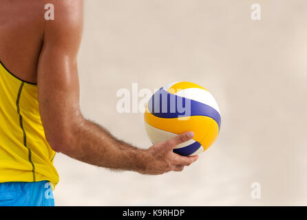 Volleyball is a male volleyball player getting ready to serve the ball. Stock Photo