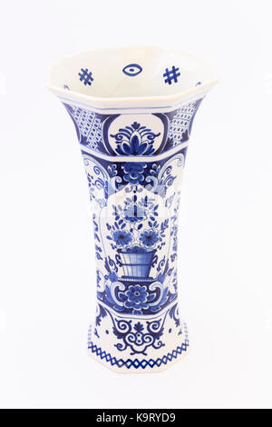 A tall ancient white ceramic flower vase painted with dark blue ornaments isolated on white background Stock Photo