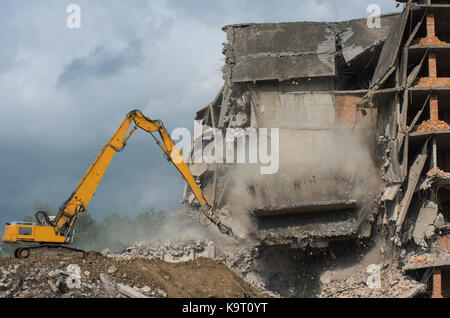 Heavy equipment being used to tear tearing down building construction. Moment of collapse. Stock Photo