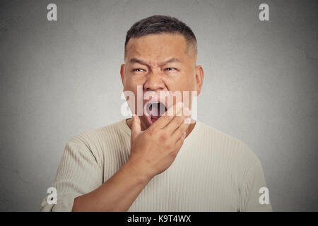 Its is too early for this meeting. Closeup portrait headshot sleepy middle aged business man wide open mouth yawning looking bored isolated on grey wa Stock Photo