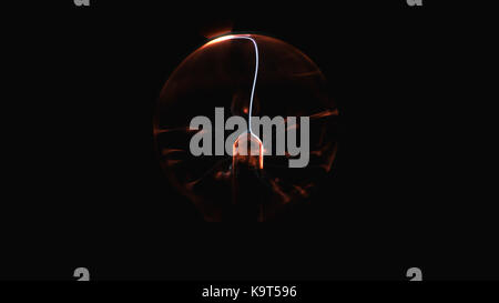 Electrostatic plasma sphere in the dark. Tesla coil - physics experiment Stock Photo