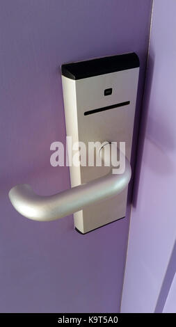 Magnetic Card Reader Door Lock on a purple door of a room in a hotel Stock Photo
