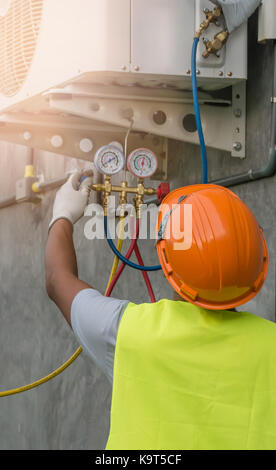 Auto mechanic uses a pressure gauge on the air compressor Stock Photo