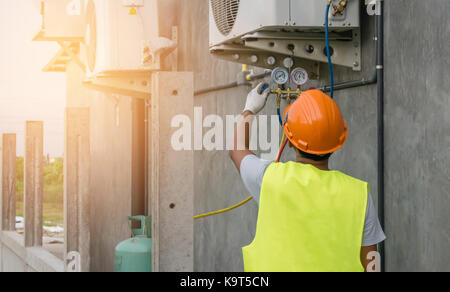 Auto mechanic uses a pressure gauge on the air compressor Stock Photo