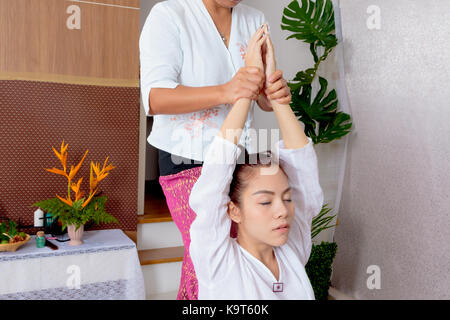Woman getting thai stretching massage Stock Photo - Alamy