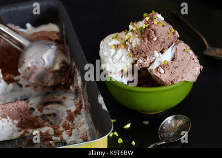 Closeup of bowl with chocolate, rhum, and pistachio ice cream on black background. Stock Photo