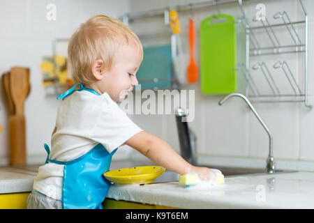 blonde child boy playing in kitchen Stock Photo