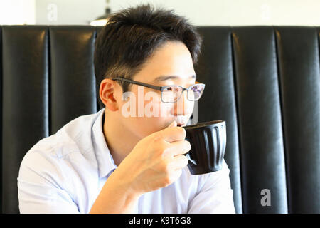 Asian young man drinking coffee in the cafe. Stock Photo