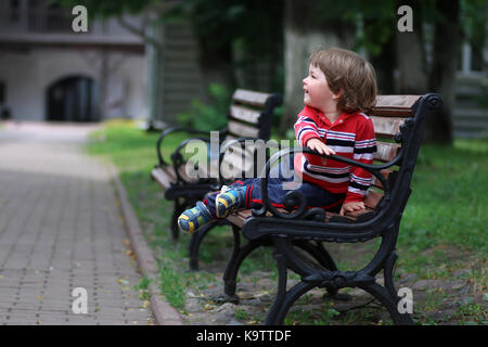 boy kid bench parl alone Stock Photo