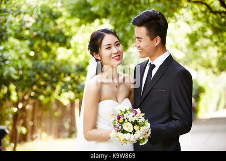 outdoor portrait of asian bride and groom, happy and smiling. Stock Photo