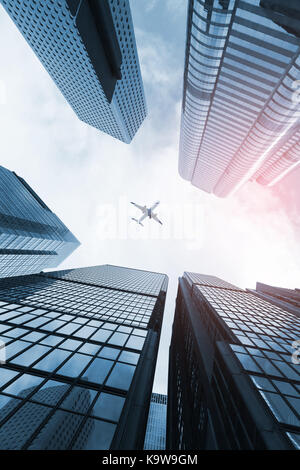 Modern skyline with passenger plane flying over business skyscrapers, high-rise office buildings of Hong Kong city Stock Photo