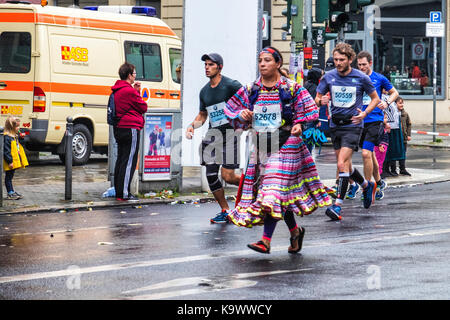 Berlin, Germany, 24th September, 2017. Athletes in unusual outfits or fancy dress competing in the Berlin Marathon reach the 10 Kilometer mark at Rosenthalerplatz. The wet weather did nor appear to dampen the spirits of the Athletes or spectators. Runners were competing in an AWMM (Abbott World Marathon Major) -  a series consisting of six of the largest and most renowned marathons in the world. Eden Breitz/Alamy Live News. Stock Photo