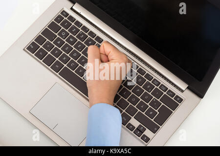 High Angle View Of Businessperson Hand Fist On The Keyboard Of Laptop Stock Photo