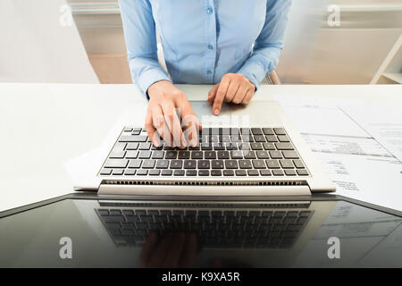 High Angle View Of Businesswoman Working On Laptop At Desk Stock Photo