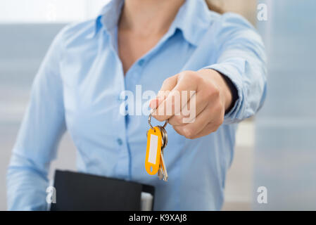 Close-up Of Businesswoman Holding Key With Folder Stock Photo