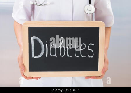 Close-up Of Doctor Showing Text Diabetes On Slate Chalkboard Stock Photo