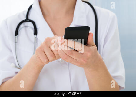 Close-up Of Doctor With Stethoscope Using Mobile Phone Stock Photo