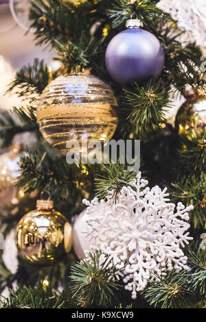 Beautiful shiny New Year decorations on Christmas tree with white showflake Stock Photo