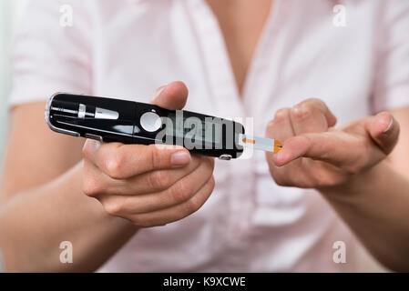 Close-up Of Woman Hands Testing High Blood Sugar With Glucometer Stock Photo