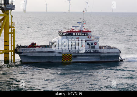 Offshore wind farm, crew transfer vessel docked on landing station ...