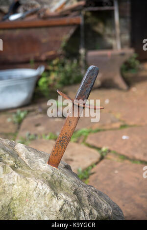 Metal sword in a stone outside the Old Working Smithy, Gunnerside, Swaledale, Yorkshire, Dales, England. Stock Photo