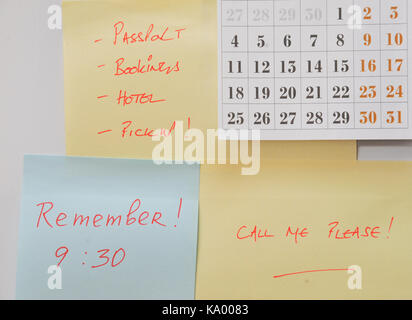Post It Notes and Calendar On Fridge with Reminders About Travel Stock Photo