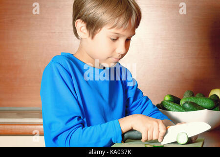 Little boy cutting vegetables in the kitchen Stock Photo