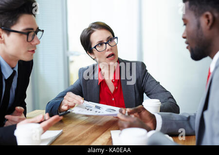 Analyzing Financial Figures with Colleagues Stock Photo