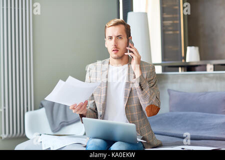 Discontent Freelancer Using Mobile Phone Stock Photo