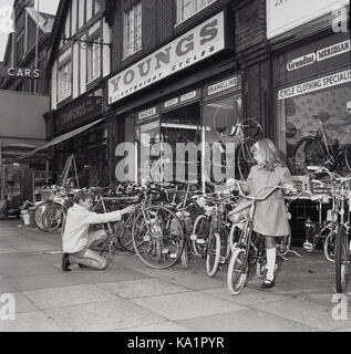 1970s historical an excited young boy and girl try out the bikes