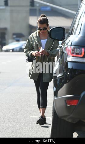 Lea Michele wearing a green hooded coat and leggings whilst out for