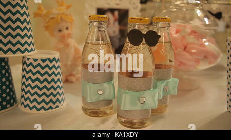 different bottles of juice on the table. Bottled drinks for guests at the party. glass bottles with drinks. Bottles Stock Photo