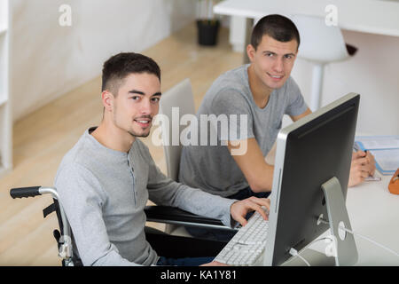 student in wheelchair working with a classmate Stock Photo