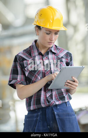 female contractor at a work site using an ipadtablet Stock Photo