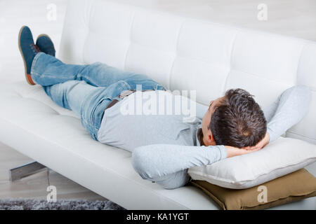 middle-aged man having a restful moment relaxing in sofa Stock Photo