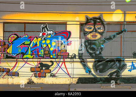 Graffiti – Cat Theme. Ratchaburi, Thailand, Jan 21, 2017: Local street art, graffiti on wall, doors and windows along terrace houses. Stock Photo
