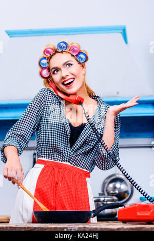 woman cooking and talking on telephone Stock Photo