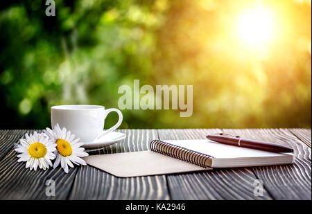 blank white notebook, pen and cup of coffee on the desk Stock Photo