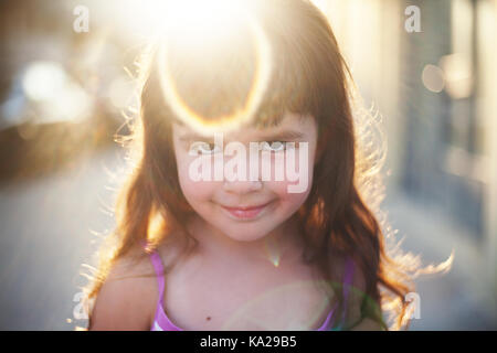Facial expression of a small girl, smiling and looks like she is watching sun rays. Stock Photo
