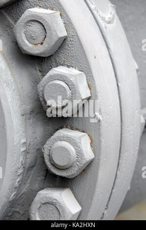 Closeup of industrial detail shows cylinder of steel wheel with exposed nuts and bolts. Stock Photo