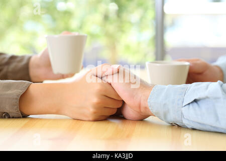 Close up of a couple hands dating and caressing in a bar or home interior Stock Photo