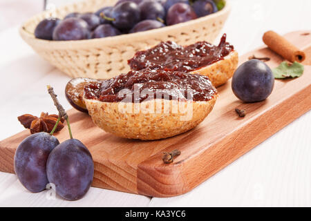 Fresh prepared sandwiches with plum jam on wooden cutting board, concept of delicious breakfast Stock Photo