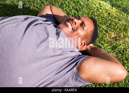 close up of smiling black man lying on grass Stock Photo